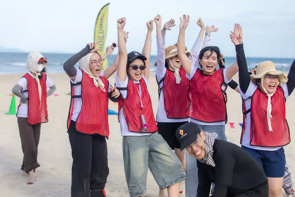 A team celebrating a win during beach teambuilding