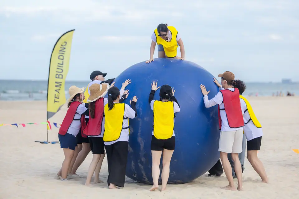 Teams pushing together in a beach challenge